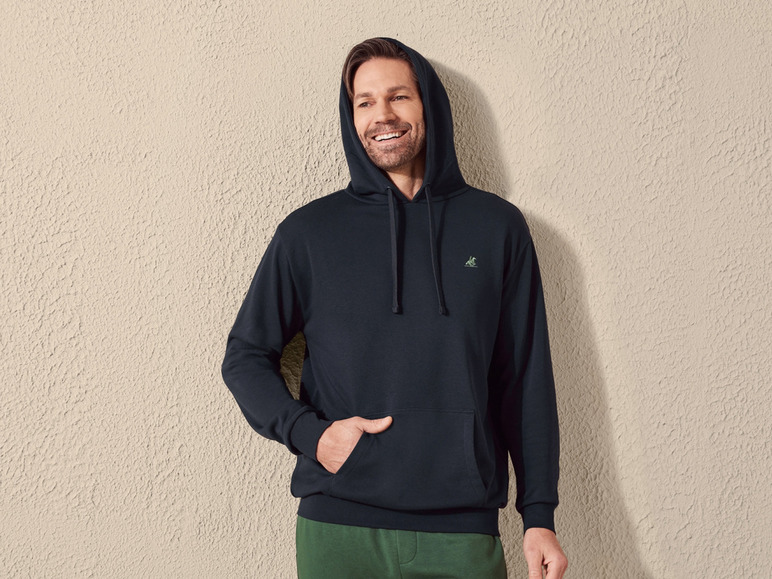 Man in een donkerblauwe hoodie met een klein logo