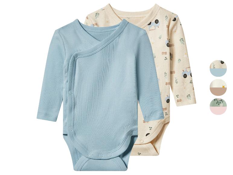 Twee babyrompertjes, één blauw en één beige met boerderijmotief, met drukknoopjes.