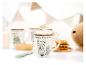 Mok met vossenprint en marshmallows, omringd door andere mokken en wafels.