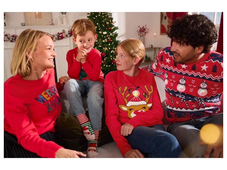 Familie in bijpassende kersttruien, lachend in een feestelijke setting.