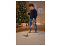Een kind gebruikt een Dyson stofzuiger op een vloerkleed voor een kerstboom.