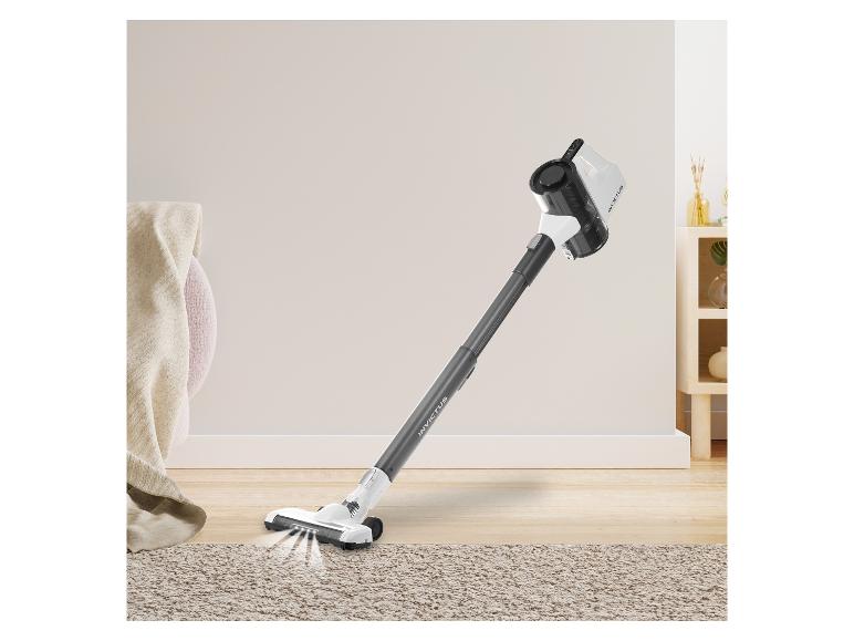 Invictus draadloze stofzuiger op een lichte houten vloer en een beige vloerkleed.
