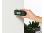 Hand houdt vochtmeter tegen een witte muur, toont 0,0% vocht en 22,0°C.