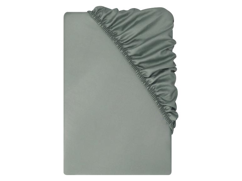 Een enkel saliegroen hoeslaken, gevouwen om de elastische hoek te tonen.