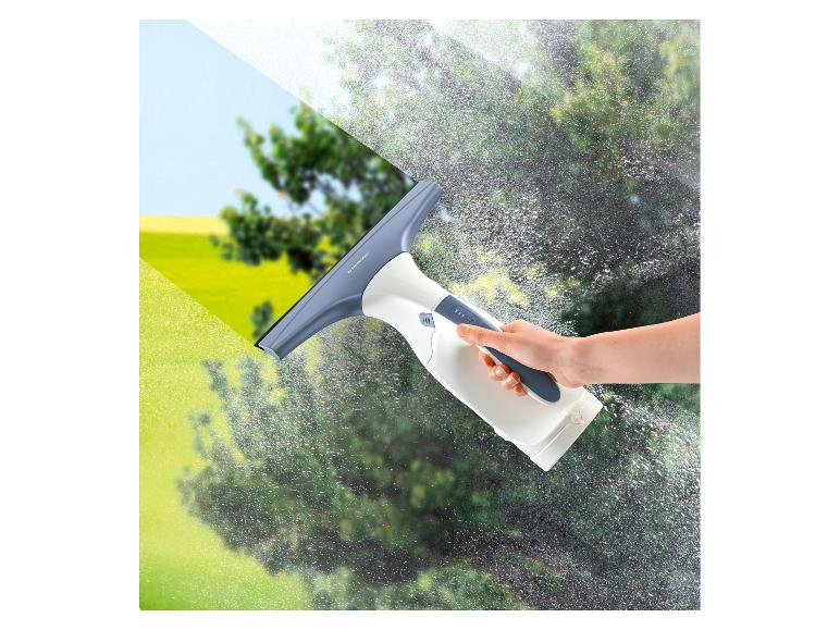 Hand houdt een raamreiniger vast, die een raam schoonmaakt met helder uitzicht