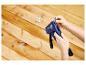 Persoon laadt LIVARNO® Handtacker »RPC7« met nietjes tegen een houten achtergrond.
