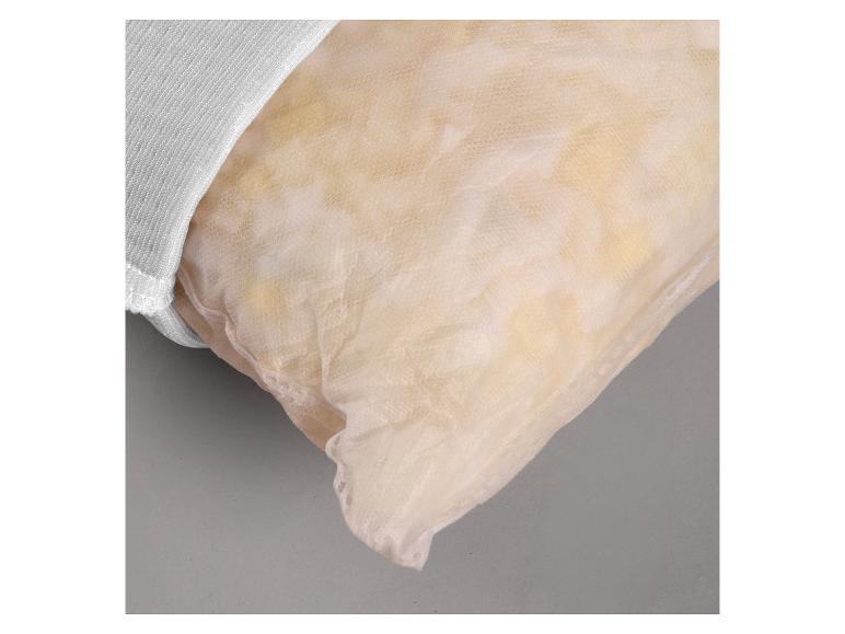 Close-up van een kussen met een lichtbeige netovertrek en een witte stoffen rand.