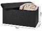 Zwarte opbergbank met open deksel en opgerolde deken, afmetingen 76x37,5x37,5cm.