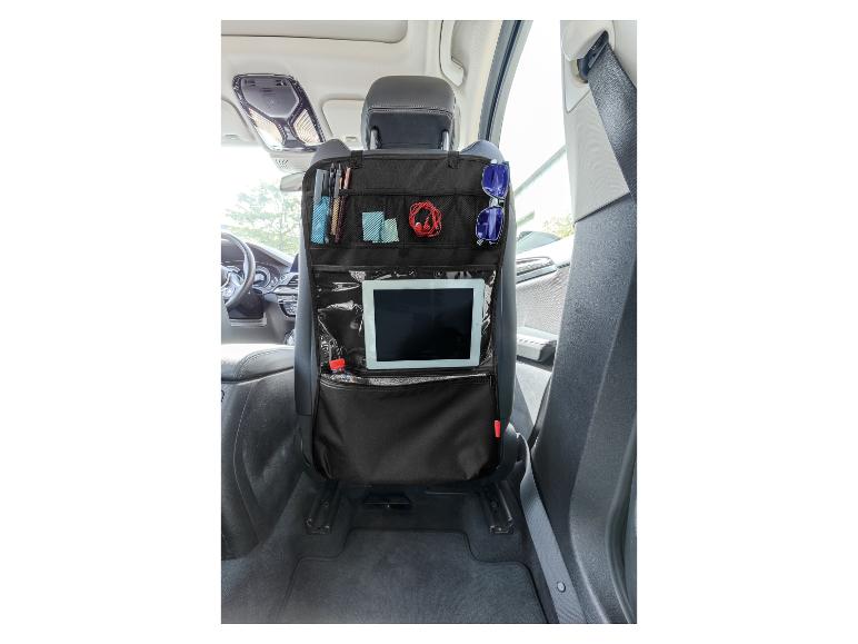 Een zwarte autostoelorganizer met tablet, zonnebril en andere accessoires.