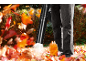 Man gebruikt een bladblazer om herfstbladeren op te ruimen.