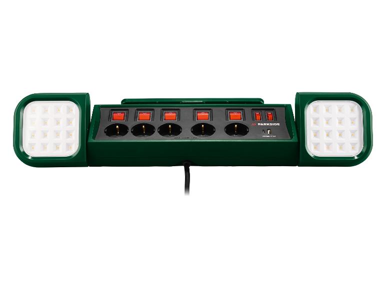 Groene stekkerdoos met vier stopcontacten, individuele schakelaars en twee LED-werklampen.
