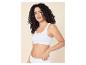 Vrouw met krullend haar draagt een witte geribbelde bralette en bijpassende slip.