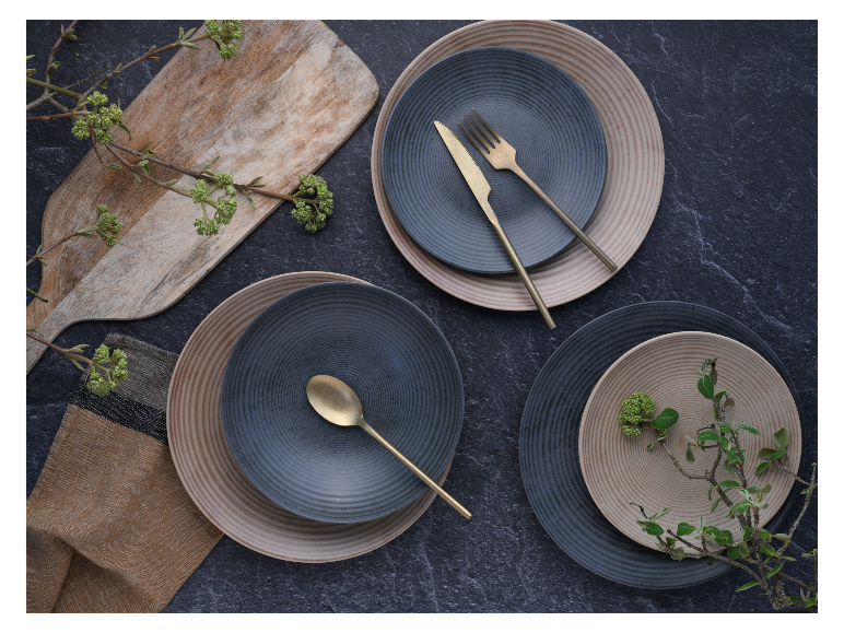 Elegant servies: borden, gouden bestek, houten plank.