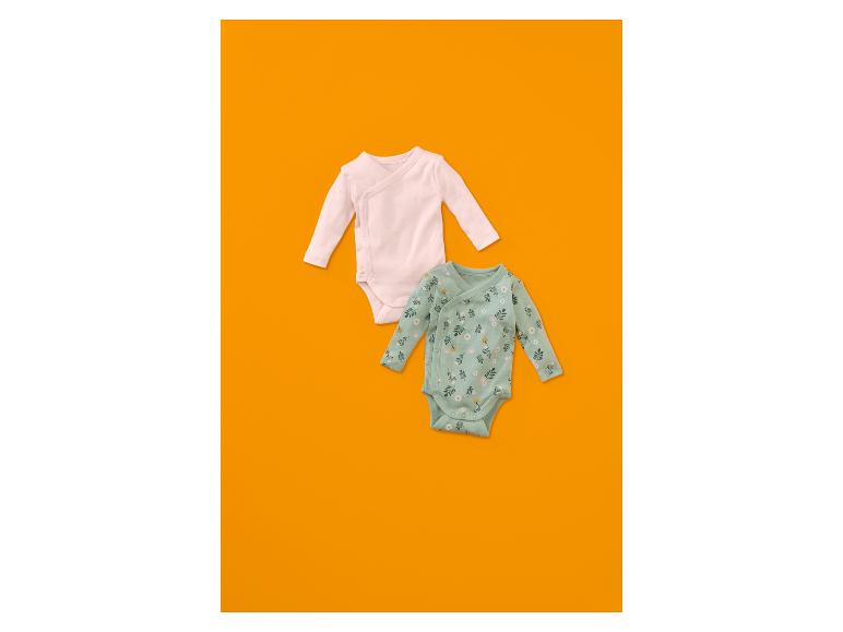 Twee babyrompertjes, één lichtroze en één mintgroen met bloemenpatroon.