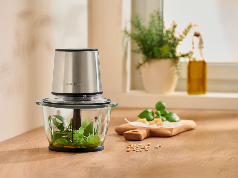 Hakmolen met basilicum en olie, klaar voor het maken van pesto.