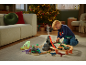 Kind speelt met trein- en dinosaurusset in kerstwoonkamer.