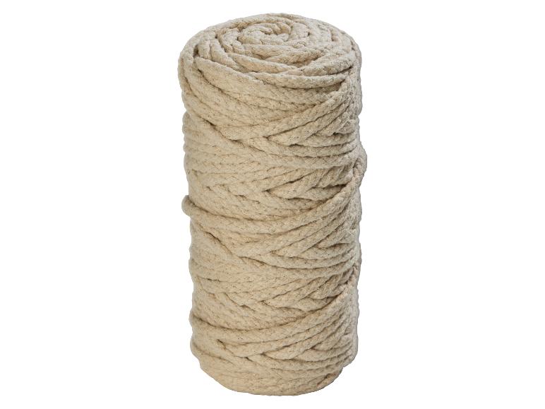 Een grote rol natuurlijk beige touw, strak opgerold en rechtopstaand.