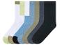 Zes paar sokken in verschillende kleuren, waaronder zwart, grijs, wit, beige, lichtblauw en groen.