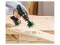 Een gat boren in een houten plank met een accuboormachine en gatenzaag.