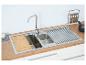 Roestvrijstalen gootsteen met houten snijplank en droogrek.