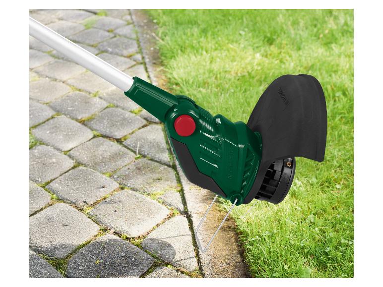 Grastrimmer naast een geplaveid pad, met gras ernaast