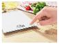 Keukenweegschaal met digitaal display, bediend door een hand, omringd door ingrediënten.