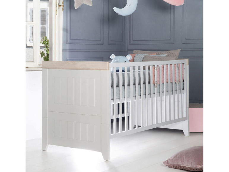 Een witte babywieg met een opberglade.