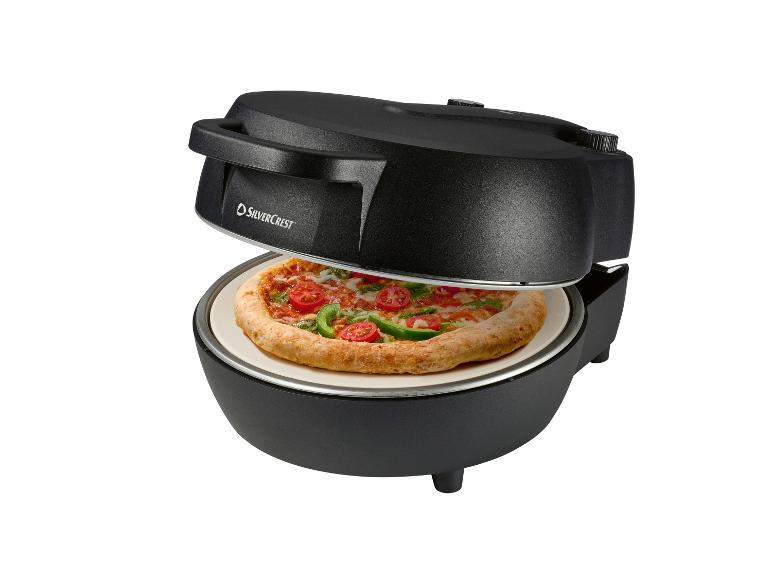 Zwarte SilverCrest pizzaoven met een pizza met tomaat, paprika en pesto.