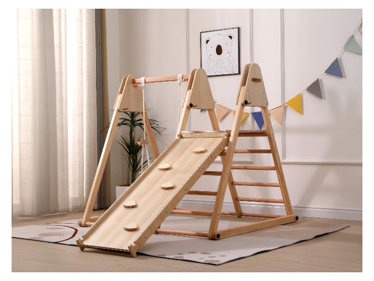 Houten binnenspeeltuin met glijbaan, klimwand en schommel in een kinderkamer