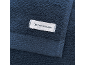 Donkerblauwe handdoek met een wit label met de tekst 'TOM TAILOR'.