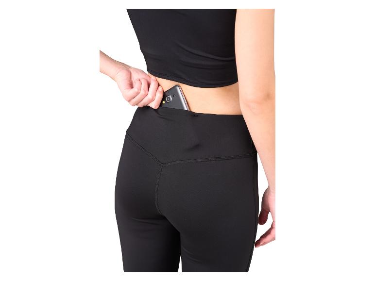 Vrouw in zwarte legging met telefoon in de achterzak.