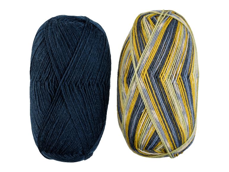 Twee bollen garen, één donkerblauw en één met gele, groene en blauwe strepen.