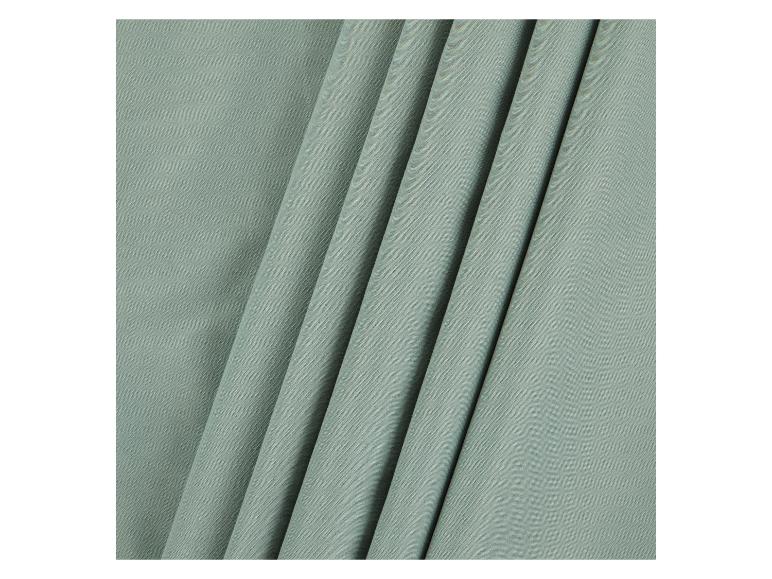 Zachte, lichtgroene stof gevouwen in plooien.
