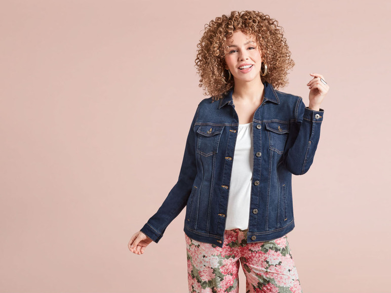 Een vrouw in een denim jack en bloemenprint broek.