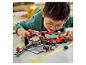 Een kind speelt met een Lego Speed Champions Ferrari pitstop set.