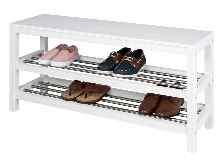 Een wit schoenenrek met twee niveaus, met daarop slippers, laarzen en sneakers.