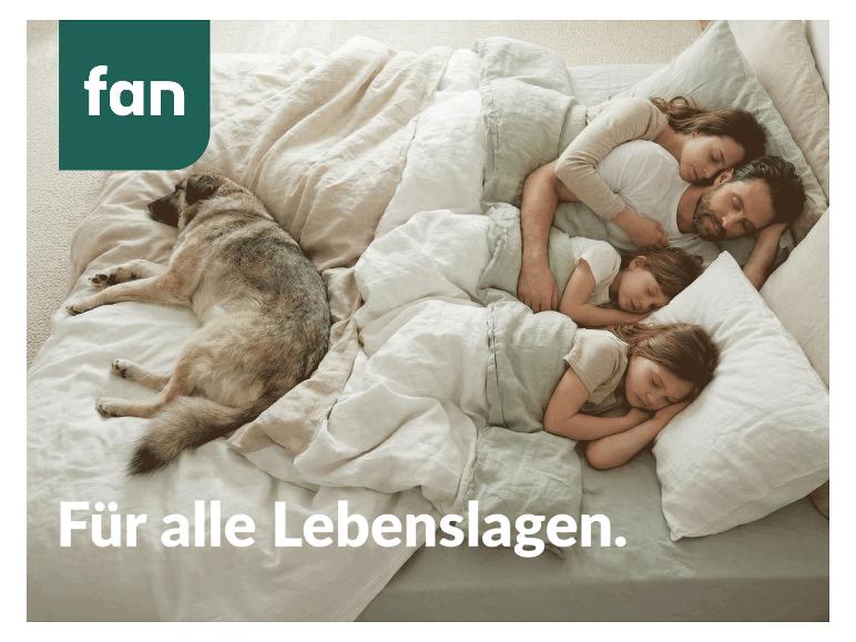 Familie en hond slapen in bed met wit en groen beddengoed, tekst 'fan' en 'Für alle Lebenslagen.'