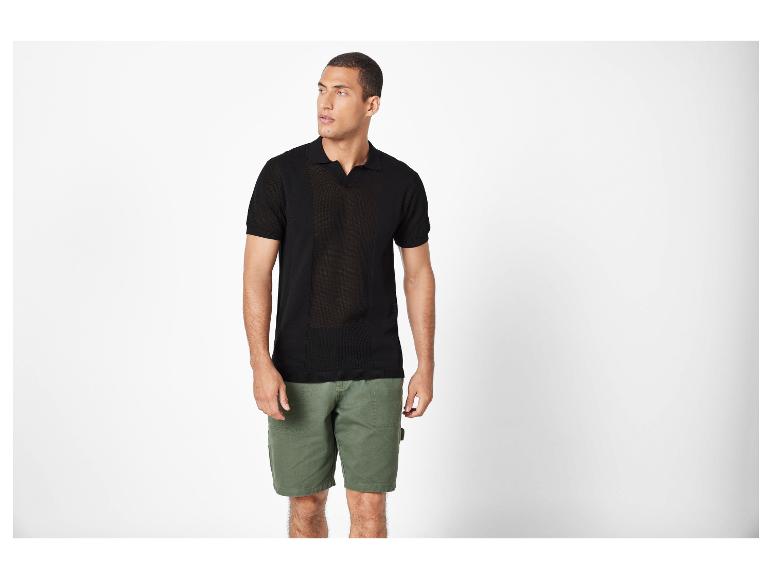 Mannenmode: zwart gebreid polo shirt en olijfgroene cargoshorts.