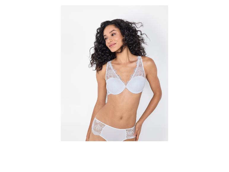 Vrouw met krullend haar draagt een witte kanten beha en bijpassende slip.