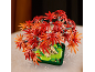 Speelgoed loofboom met rode en oranje bladeren, in een groene pot.