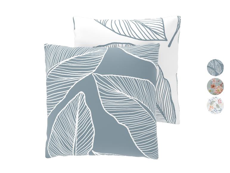 Twee decoratieve kussens met bladpatroon in blauwgrijs en wit, met patroonstalen.
