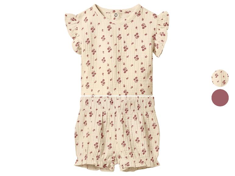Tweedelig babyoutfit met bloemenpatroon, inclusief een top met ruchesmouwen en een short.