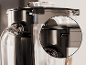 Close-up van een sapcentrifuge met transparante kan en zwart deksel.