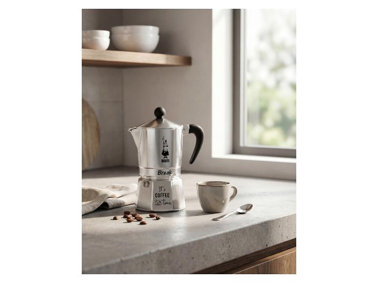 Zilveren koffiezetapparaat met de tekst 'It's coffee time' en een kopje op het aanrecht.
