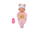 Zachte babypop in een roze kruippakje en een kleine roze zuigfles.