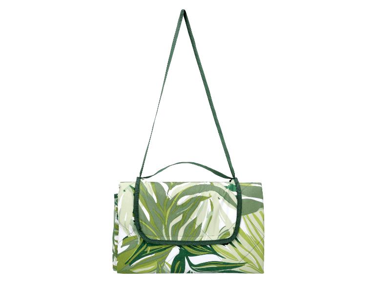 Groen-wit picknickkleed met bladpatroon en draagriem.