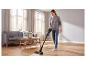 Vrouw stofzuigt de houten vloer met de SILVERCREST® accu-stofzuiger.