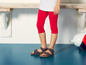Rode leggings met strikjes en blauwe sandalen.