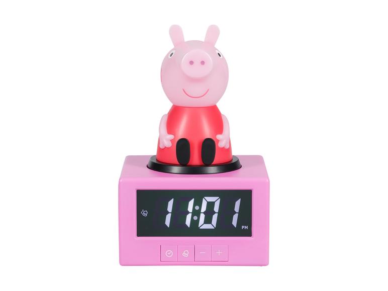 Roze digitale wekker met een varkensfiguur erop, die 11:01 PM weergeeft.