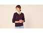 Vrouw in een bordeauxrode cardigan over een wit overhemd, met lichte jeans.